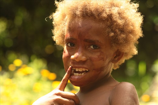 Young girl walking around in the kastom village after helping her mother weaving traditional baskets. Lekalangia, Tanna, Vanuatu.