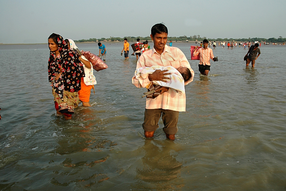 At the Low Tid Time A Father crossing Matla River with a New Born Baby 
