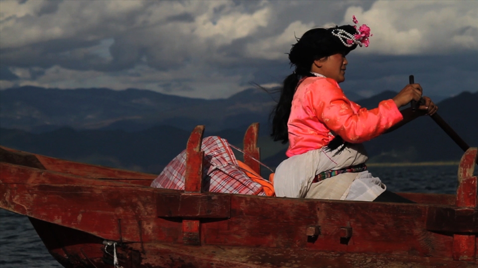 One of the local women rowing tourists over the lake