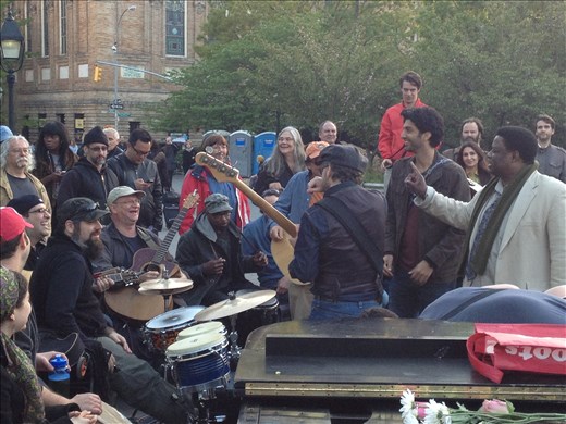 Washington Square Park has the uncanny effect of bringing strangers together to interact and revel. Here the park's street musicians, normally spread around different parts of the park, have come together to jam as a large crowd of onlookers gathers. Most of these musicians are regulars who have become fixtures of the park's culture.