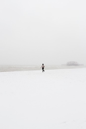 My friend Alistair and I were working together in Brighton when a sudden flurry of snow started falling down upon Brighton. On our lunch break we cut out of the office and headed to the beach. Once there, in a spontaneous moment, Alistair started running wildly towards the ocean, his arms aloft and waving in the excitement of the moment as the West Pier loomed in the background like an ominous shadow.
