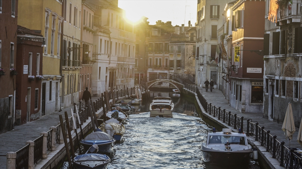 The canals brighten as the mist slowly disappears.