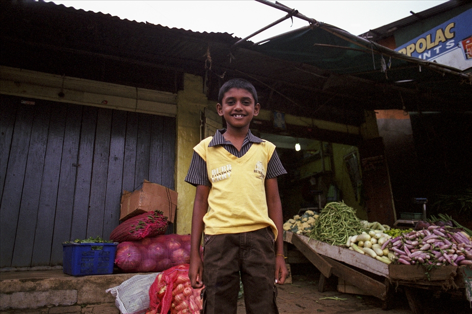A scrawny lad, waiting for the train to load produce from the family farm