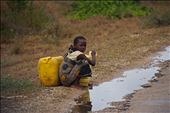 A young girl collects rainwater from the side of the road.: by mattsjournal, Views[494]