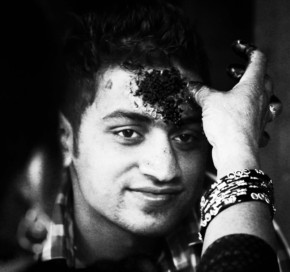 Everyone receives Tikas—blessings of petal-dyed rice applied to the forehead.