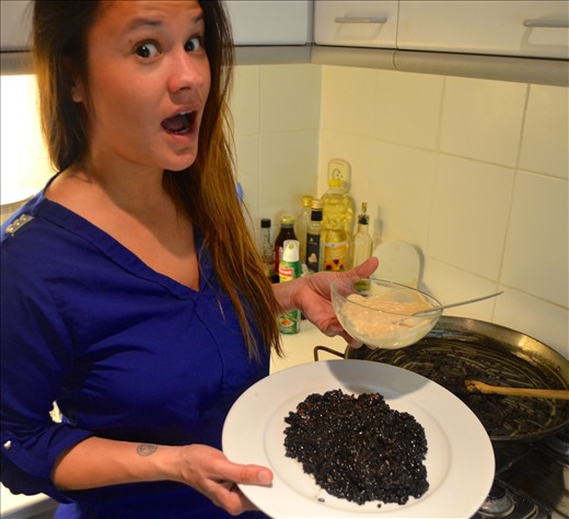 In one hand the black rice and in the other the homemade alioli