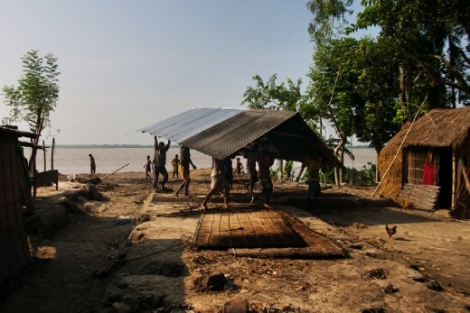 Displacing settlements - Villagers are forced to relocate as the river erodes away their lands mercilessly. Riazul, with help of others, moves his housing infrastructure to a less vulnerable site, before the cataclysmic river erosion displaces his home.