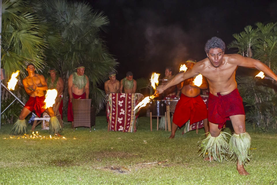Samoan culture is highly social and here the use of the coconut tree leaves can be seen used for leg and neck decorations for the dancers and musicians performing the traditional fire dance at the end of an evenings meal and entertainment.