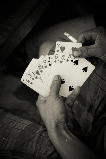 A cross cultural connection - Cards. Amazing how where ever your are playing cards is great way to pass the time. I was walking around the fishing village and snapped this picture of one mans hand of cards. They were waiting for the fishermen to come back from being out to sea.