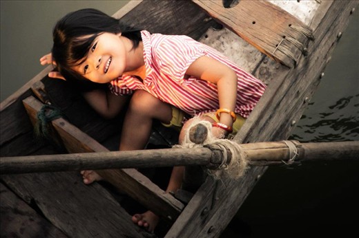 Pure Innocence - While watching the traffic jam in the water of boats coming into sell food at the market I glanced down to see her beautiful smiling face. She played a bit of hide and seek with me....by the time I ran to the other side of the bridge I was able to capture her 