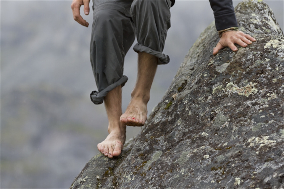 After Bouldering for a while in Hatcher Pass, Ak Seth Richardson's feet start to bleed on the wet slab of rock covered in spots of lichen. 