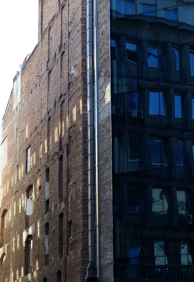 A stark contrast between the brick of old and the glass of new. 