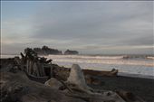 Dawn on Rialto Beach. As the sun kisses the top of the waves the mainland remains shrouded in early morning shadow. Hints of blue sky quickly dissipate as clouds roll in from offshore. A shelter is visible providing some relief from the wind and rain later that day.: by mhitchner, Views[542]