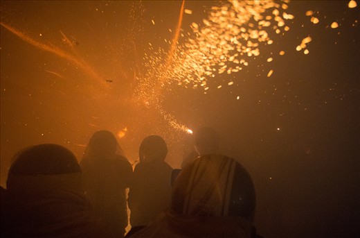 Smoke fills the area as bottle rockets continue blazing past everyones' heads.