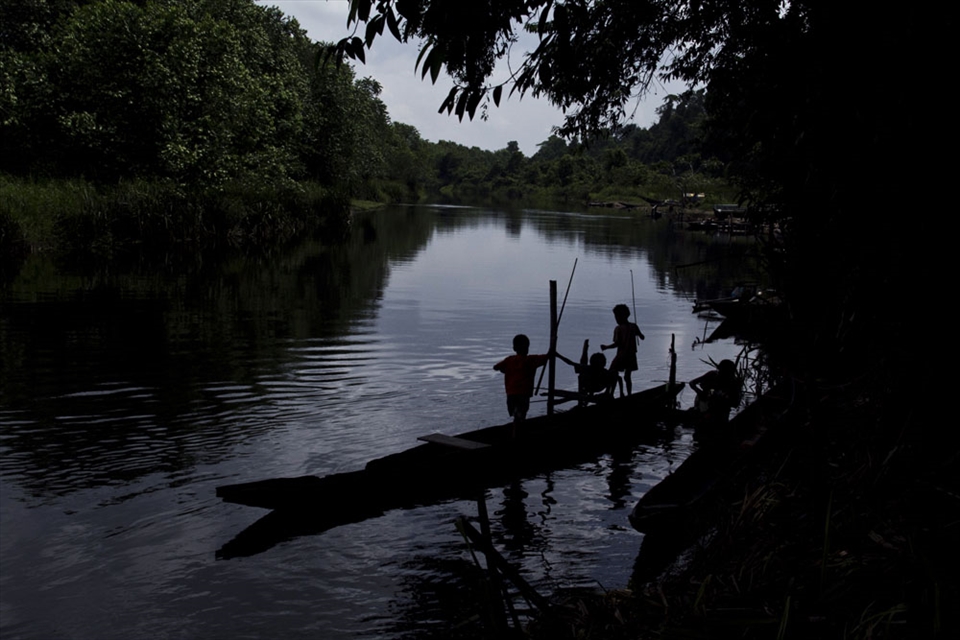 Papua children playing and fishing in the river bank of Kais River