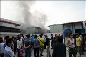 A crowed of local Chinese gather around as large pillars of smoke start emanating from a nearby building.: by michaelt, Views[258]
