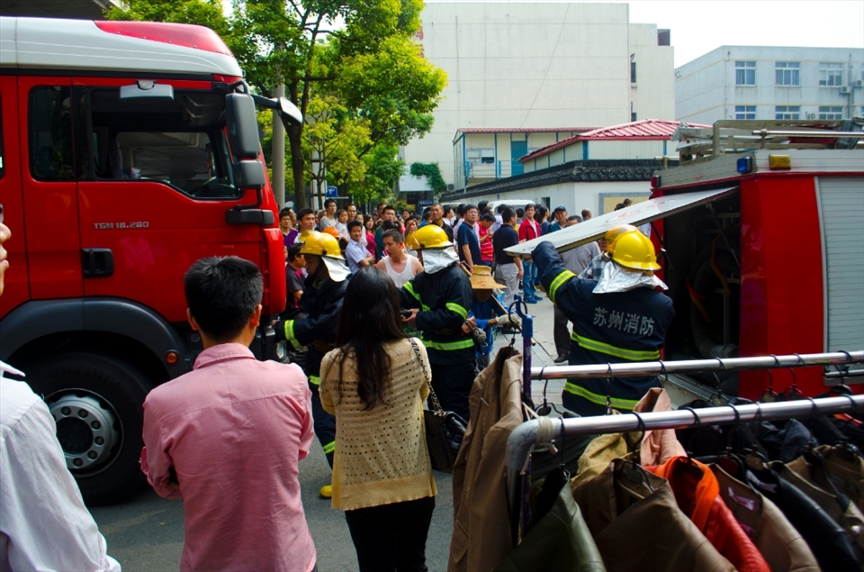 As two firetrucks arrive the firemen quickly jump out and begin preparing their equipment.