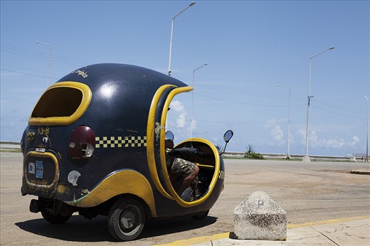 A Coco-taxi waiting for a fare on the Malecón. A product of the scarcity of raw materials and imported goods, a scooter is turned into a coconut shaped carriage.