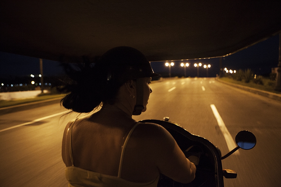 Analise, a mother of three driving a Coco-taxi at night. Taxi drivers are often supporting a large family including; children, parents and the families of their brothers and sisters on a single income.
