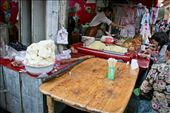 Food is a central part of the Uyghur culture. When Uyghurs meet with friends or family the generally share a meal, and if they don't share a meal they will at least have a snack of some sort. 
This stall was set up in the extreme heat of summer, so they are serving a favorite dish of cold noodles on the right, and on the left, a special treat for dessert or a snack - Uyghur homemade ice cream.: by michelledeacon, Views[656]