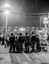 In the background of this picture, there is a little community centre situated atop a sari shop. There is a pink cement widing staircase that leads up to a verandah where two women had been pounding little pieces of dough into chapati. Every night after the puja, the community centre gives out food to the poor and homeless. We were there to help distribute the food. While waiting for everyone, I turned back and saw this group of policemen. There were non-functional metal detectors located all along the entrances to the ghats. There were policemen watching the puja from higher up with their big big guns. I snapped a picture when I finally saw one of them smile.: by michellek, Views[661]