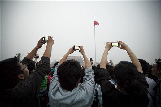 Consumer goods boom: Chinese tourists capture the lowering of the flag in Tiananmen Square, Beijing, on their smartphones. China has over one billion mobile phone subscribers, making it the world's largest mobile phone market. About 80% of the population uses a mobile phone, and about 45% of the population has internet access. Demand from the growing middle class recently led China to surpass the US as the world's leading consumer of smartphones.
