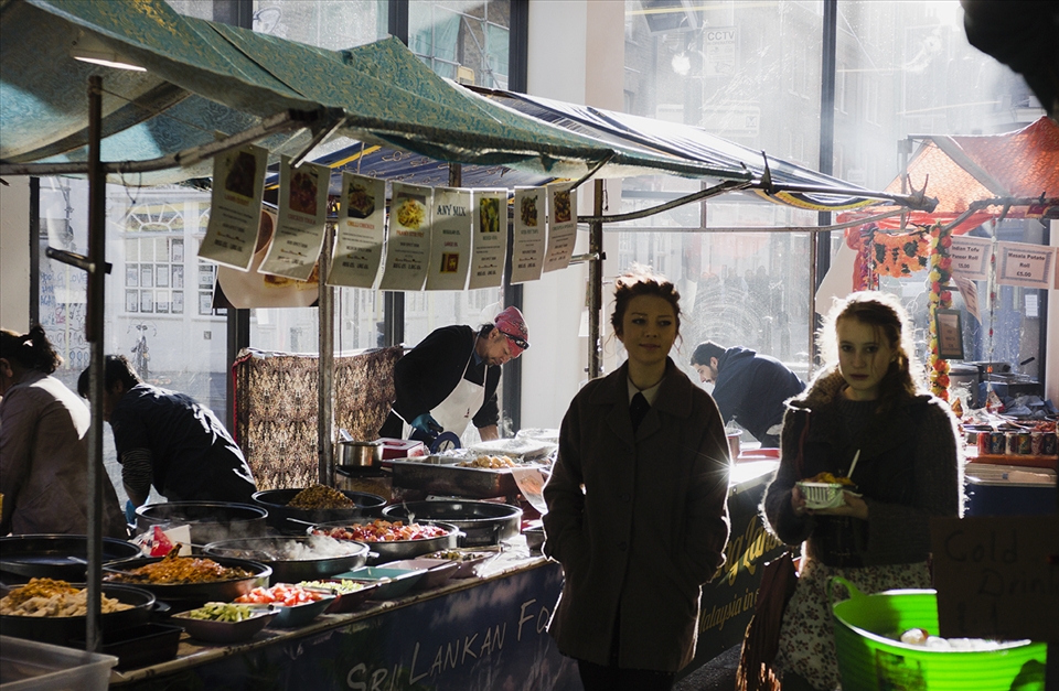 Two girls stroll around the Food Hall market in Brick Lane