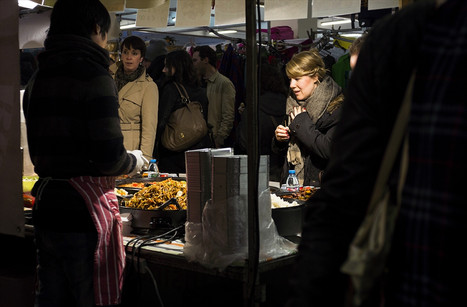 A lady finds it hard to choose wich chinese dish to eat. At Food Hall market in 