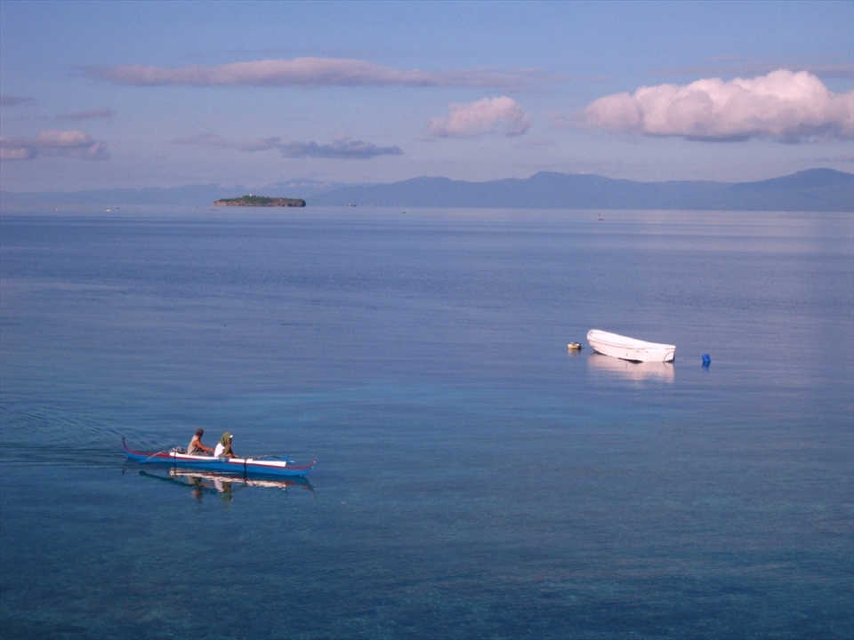 Calm waters of Moalboal.

Moalboal is a small beach town in the Philippines that was once famous for scubadivers. These days, the divers have move onto more popular sites leaving a small quiet strip of guesthouses, the odd diving shop and locals. The peacefulness and serenity of the town is reflected in the calm glasslike waters, only disturbed by the soft paddling of local boats. 