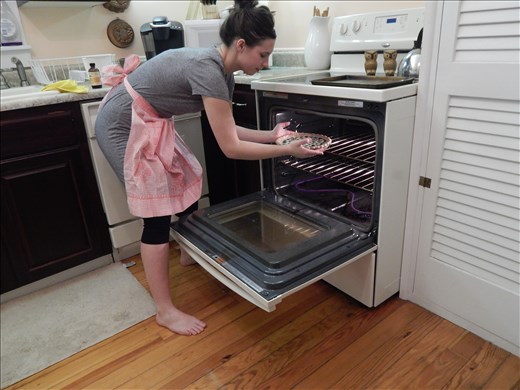 Placing the pie into the oven for baking.