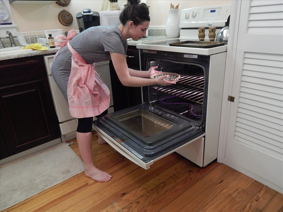 Placing the pie into the oven for baking.