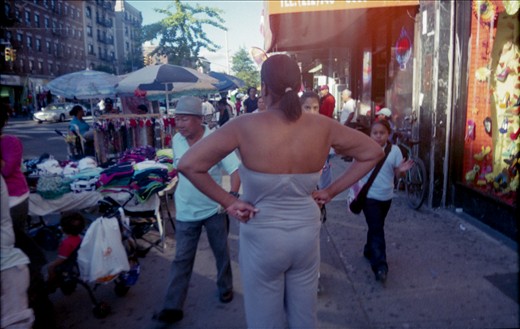 A woman creates her own island in the sidewalk; also: cool and warm colors.