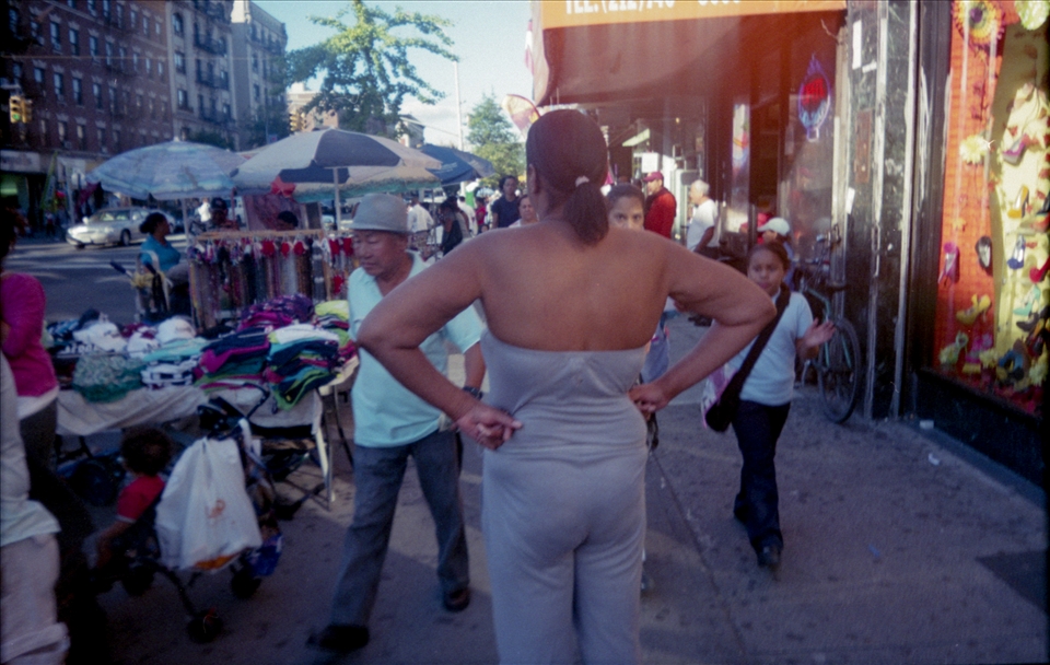 A woman creates her own island in the sidewalk; also: cool and warm colors.