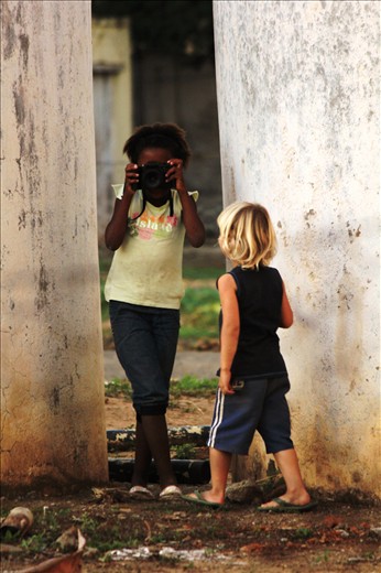 As they were playing, they suddenly ran off, bringing back their toy camera. Black and white playing together, photographing their future through their eyes.