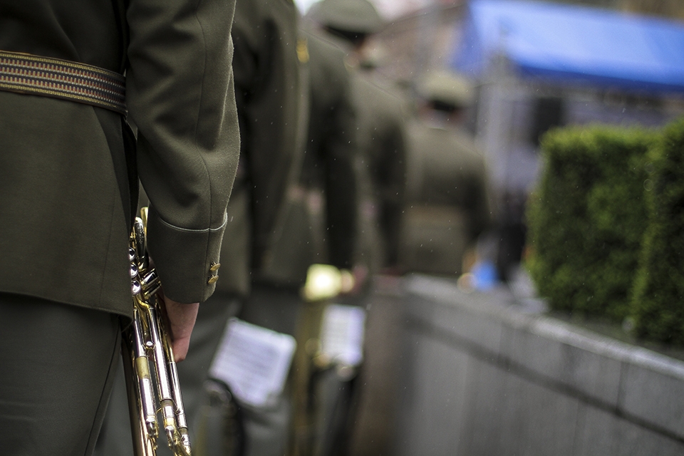 Musicians wait to play as a soft rain lands on a celebration in Pilsen.