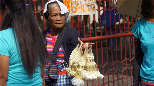 An elderly woman selling Sampaguita just outside the gates of Baclaran church.