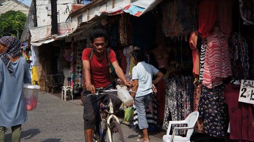 On his way to work before this side of the street becomes busy with shoppers.