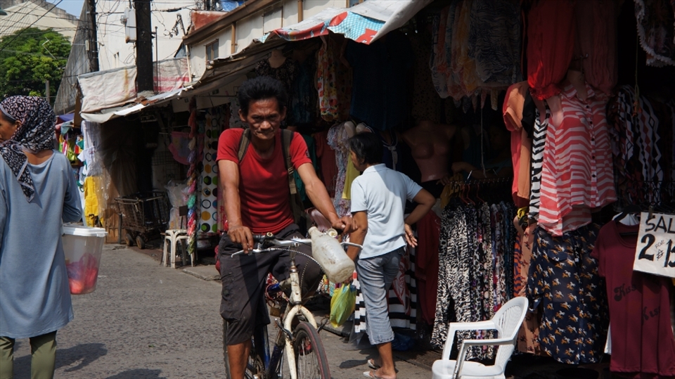 On his way to work before this side of the street becomes busy with shoppers.