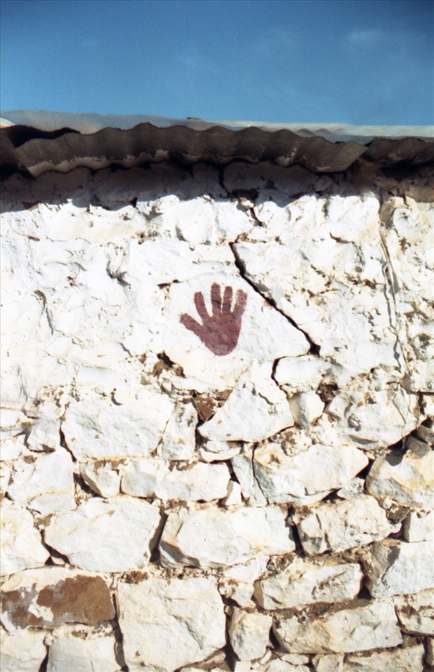 impressed hand on the stone wall. behind the beach