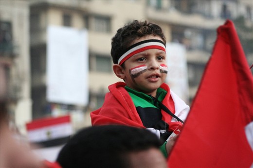 The Egyptian revolution is not a temporarily event, it’s an ongoing concept of freedom and courage of speech made through peaceful protesting. In this photo shows a child in Tahrir Square colored with the Egyptian flag colors, being an eyewitness for this historical changes that takes place all around the area recently.  