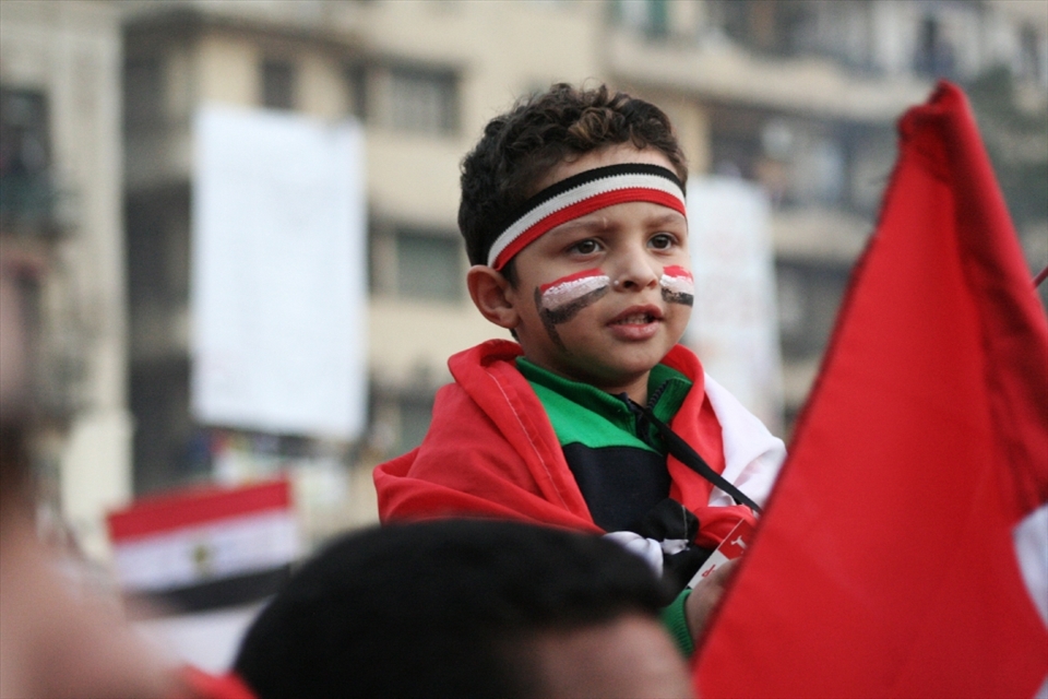 The Egyptian revolution is not a temporarily event, it’s an ongoing concept of freedom and courage of speech made through peaceful protesting. In this photo shows a child in Tahrir Square colored with the Egyptian flag colors, being an eyewitness for this historical changes that takes place all around the area recently.  
