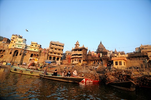 A view of Varanasi's cremation ghat, commonly known as Manikarnika Ghat. As per the Hindu mythology belief,  the person who is cremated here on sandal wood logs, gets salvation (moksha) from the re-birth cycle. There are a huge number of dead bodies brought here every day for cremation and it also attracts a lot of International tourists where they view the cremation process either from a boat in river Ganges, or just walk across the ghat.