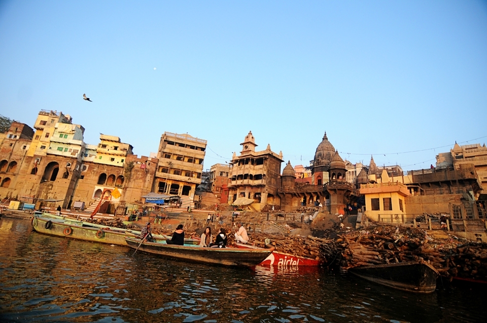 A view of Varanasi's cremation ghat, commonly known as Manikarnika Ghat. As per the Hindu mythology belief,  the person who is cremated here on sandal wood logs, gets salvation (moksha) from the re-birth cycle. There are a huge number of dead bodies brought here every day for cremation and it also attracts a lot of International tourists where they view the cremation process either from a boat in river Ganges, or just walk across the ghat.