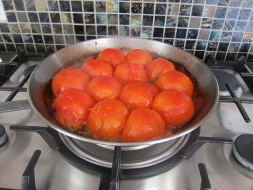 Place each of the tomatoes facing down and let them simmer over a low fire.