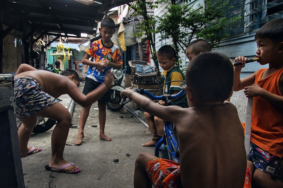 Kids smash clay onto the ground as entertainment, in the ally of the slums