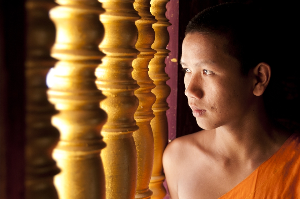 A young monk looks out of the window of Xieng Thong Temple in Laos' capital Luang Prabang. The educational opportunities for monks in Laos are limited. If he is lucky he might get the chance to study in Northern Thailand like some of his fellow monks. 