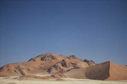 Sand Rising - Located in the world oldest desert, the sand dunes and mountains of the Namib-Naukluft National Park make up the 4th largest game park in the world covering an area of almost 50,000km2. A unique landscape with unique ecology and average annual rainfall of only 100mm per annum. Sand dunes rise to heights of greater than 300m, creating a imposing barrier to the cold southern atlantic winds which bring vital moisture to the landscape. Namib-Nauklft National Park, Namibia.