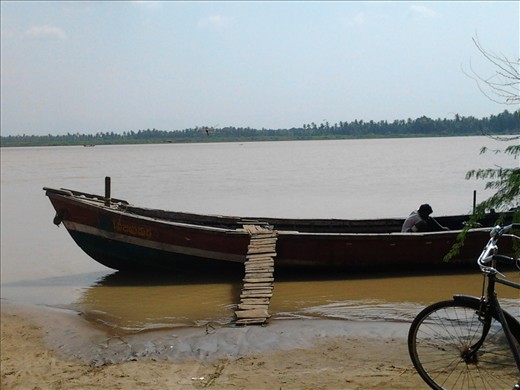 A worker repairing a boat at the river bank which their primary transport  