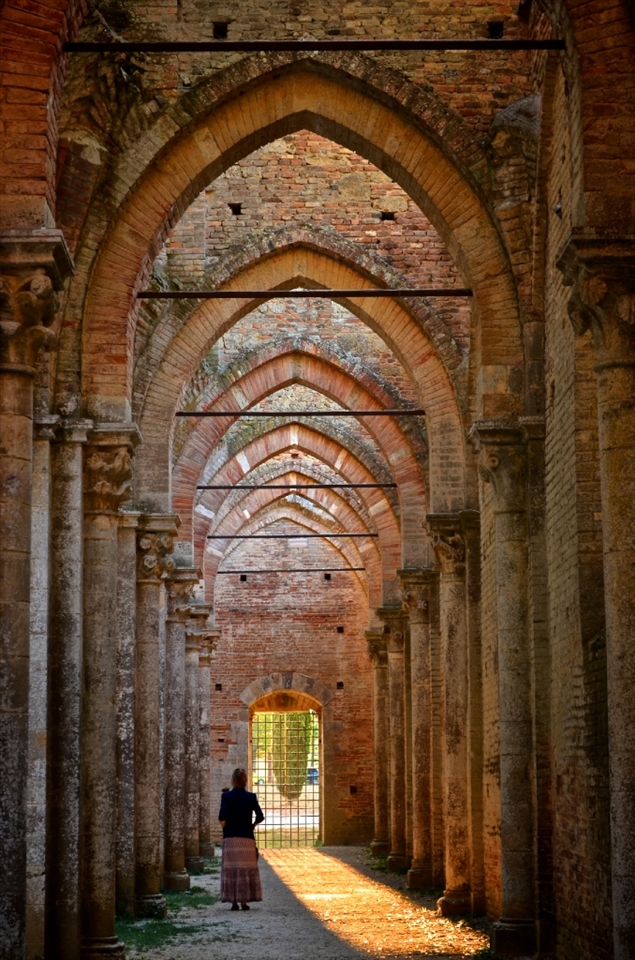 A woman absorbs the ruins of the famous abbey at San Galgano. Many say that the legend of Excalibur originated in this area. 