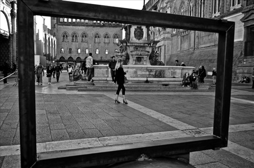 A woman walks with confidence past the Fountain of Neptune in Bologna, Italy. Italians are known for their innate sense of style and fashion in all walks of life. 